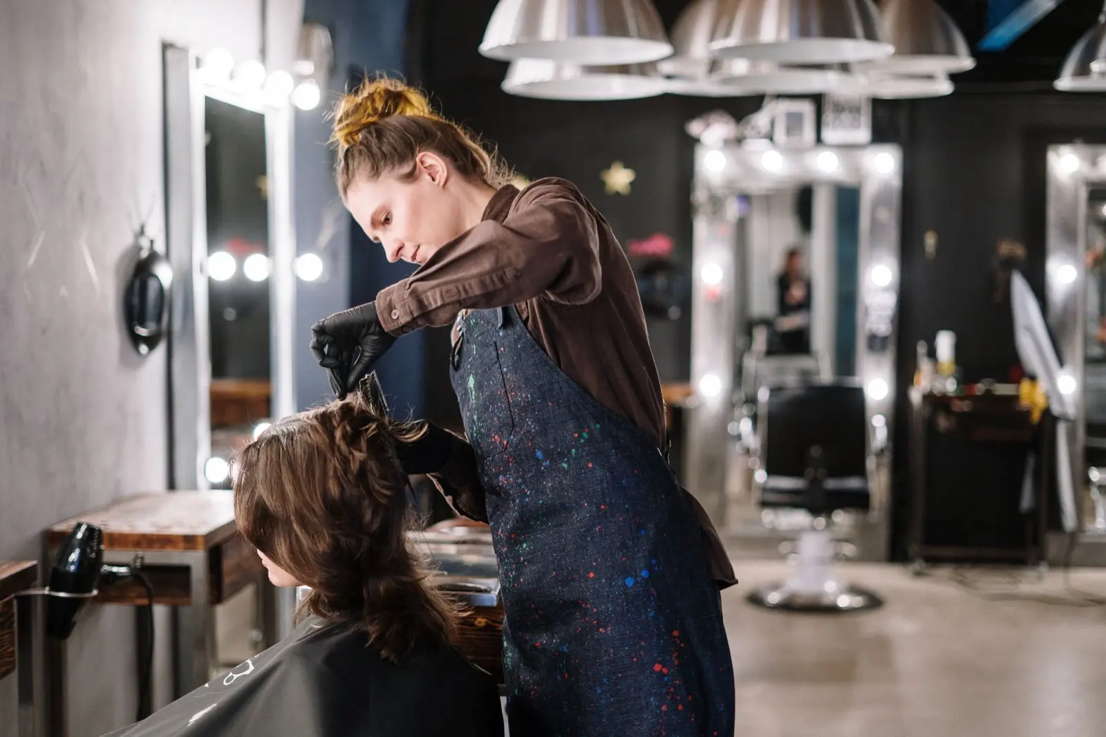 Marko bei der Arbeit, föhnt einer Kundin die Haare im Salon