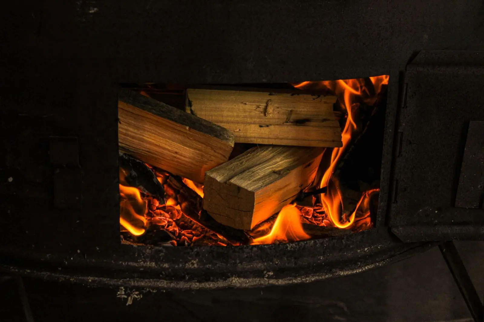Scheitholz brennt hell in einem gusseisernen Ofen