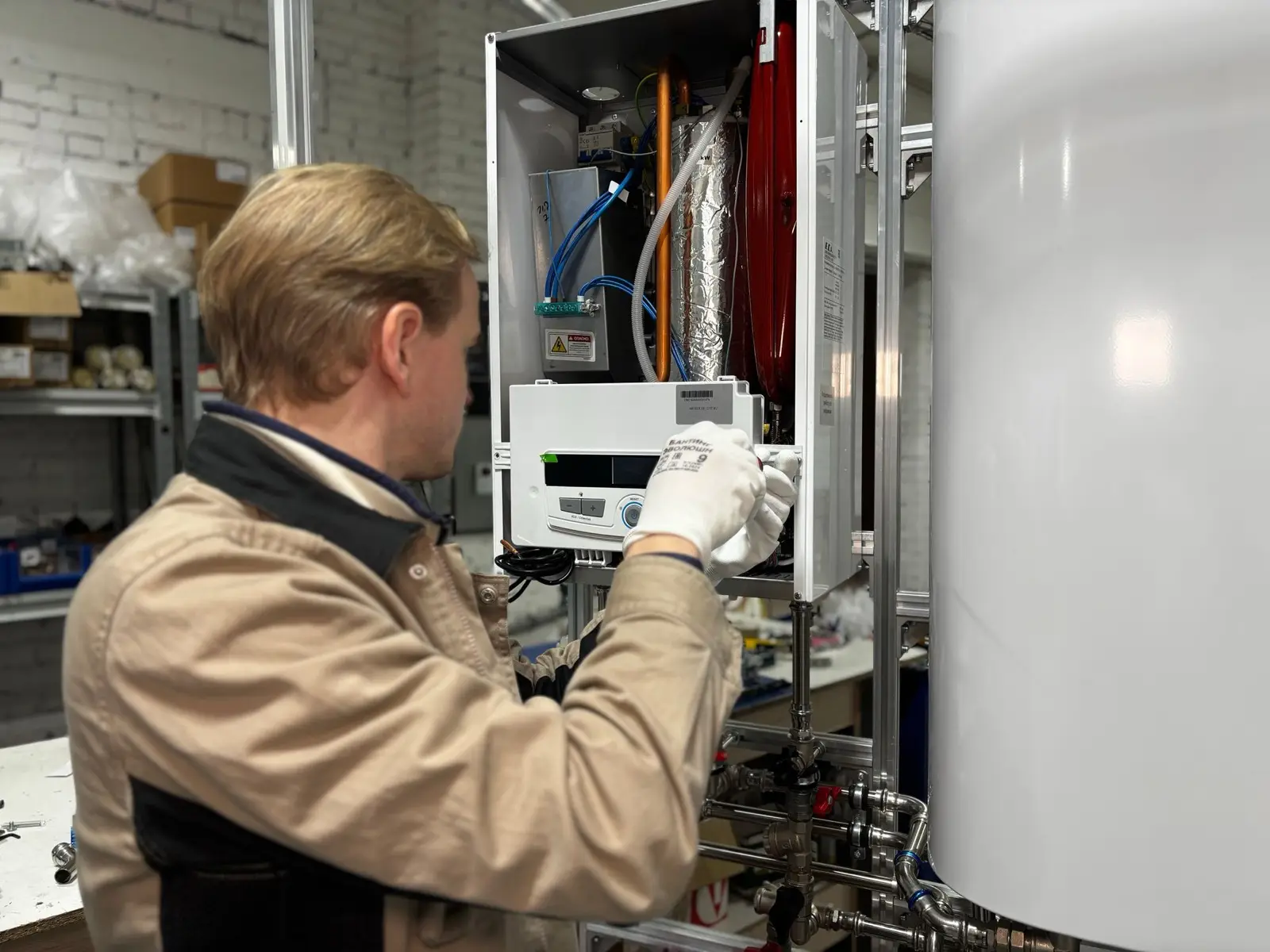 Techniker prüft eine geöffnete Gastherme mit Handschuhen